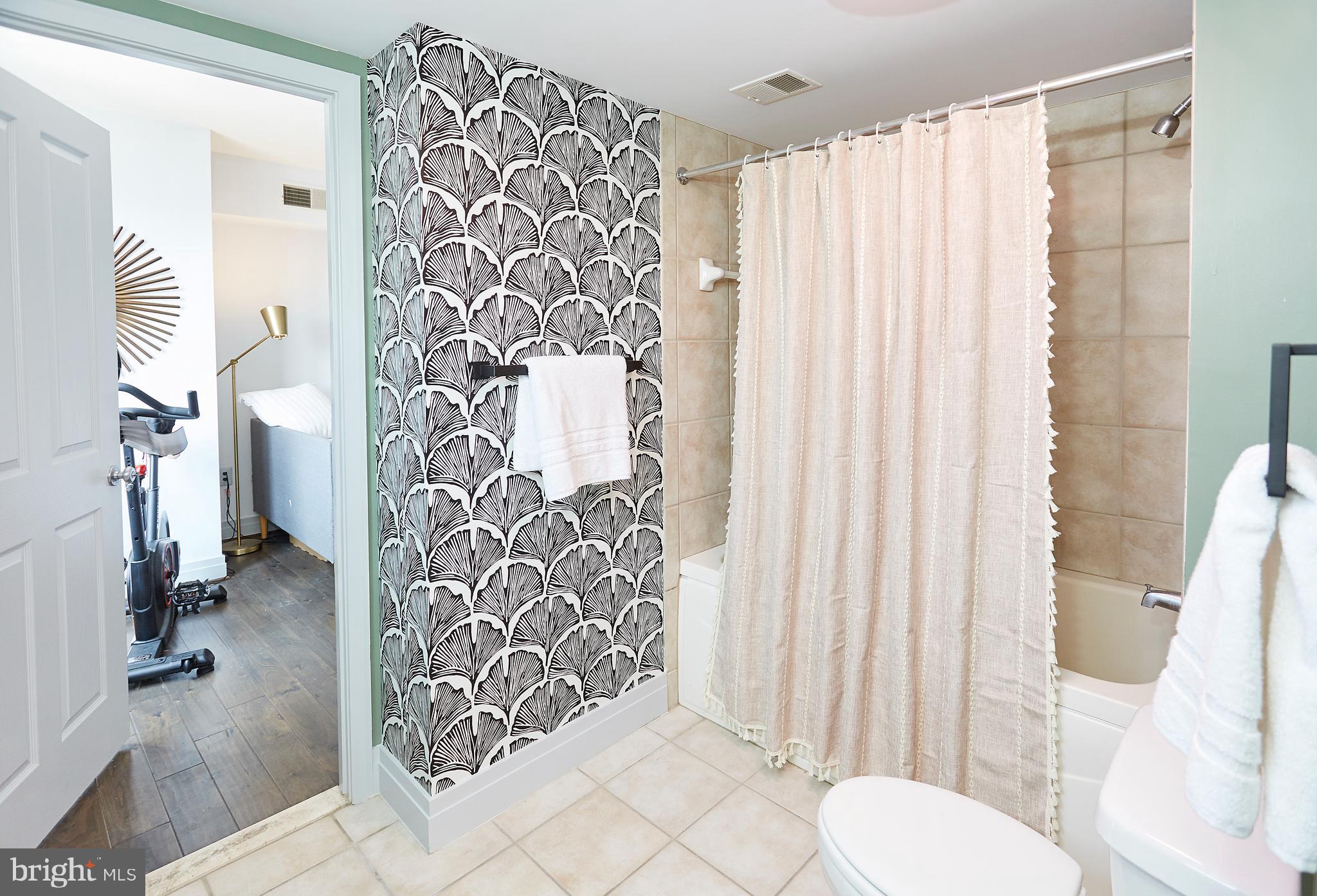 414 Water Street, Unit 2601 Baltimore, MD 21202 - Photo 34 of 51 a bathroom with a toilet and shower curtain