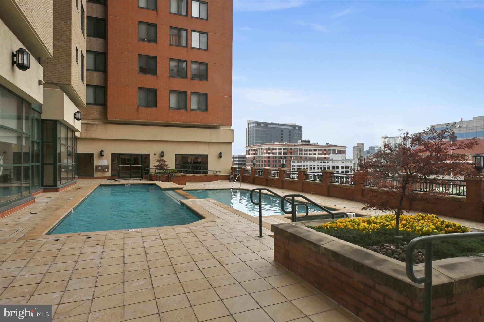 414 Water Street, Unit 2601 Baltimore, MD 21202 - Photo 45 of 51 a view of a swimming pool with a lounge chairs