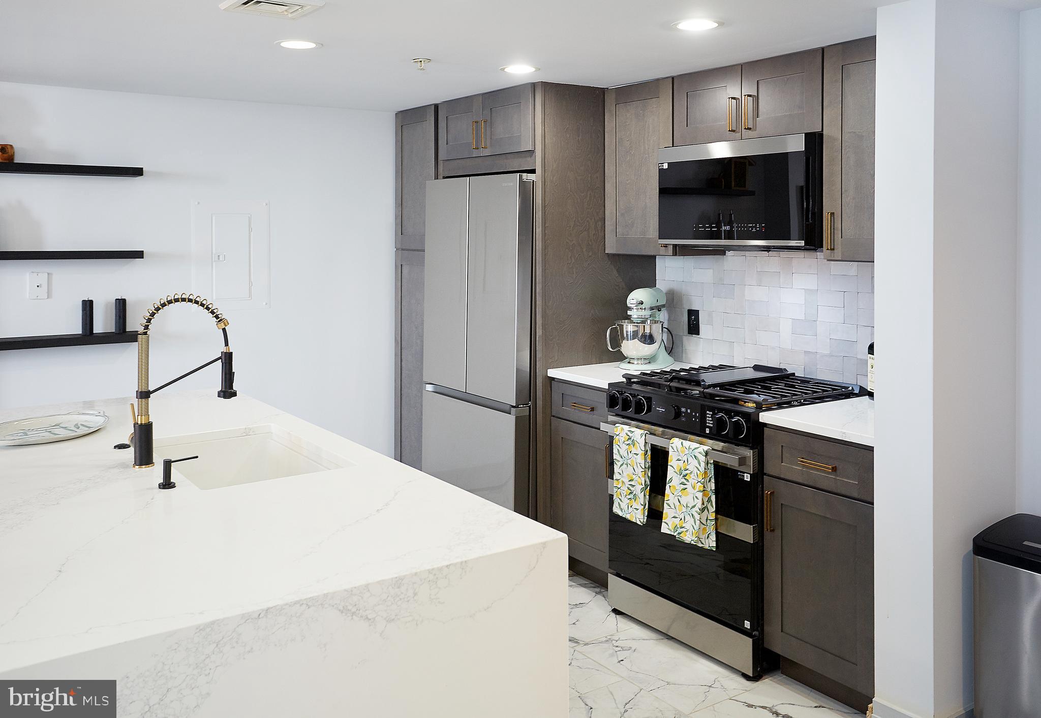 414 Water Street, Unit 2601 Baltimore, MD 21202 - Photo 7 of 51 a kitchen with stainless steel appliances a sink a stove and a refrigerator