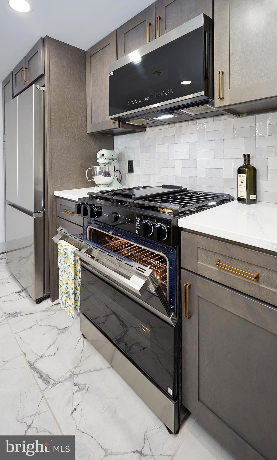414 Water Street, Unit 2601 Baltimore, MD 21202 - Photo 10 of 51 a kitchen with stainless steel appliances granite countertop a stove and a microwave