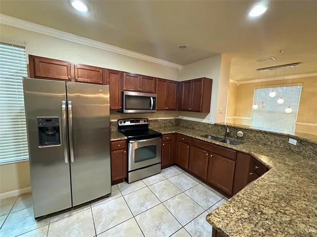 a kitchen with stainless steel appliances granite countertop a sink and stove top oven