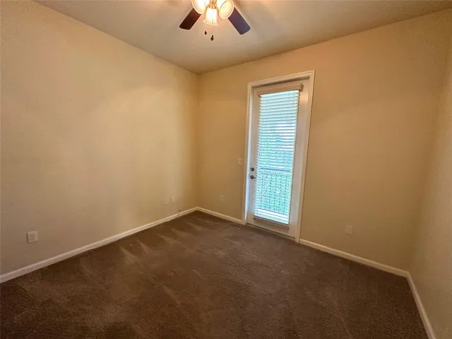 an empty room with closet and a chandelier fan