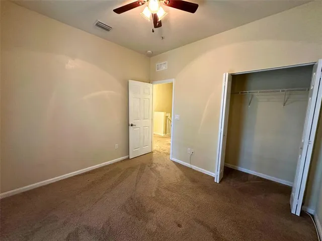 an empty room with a window and a fan