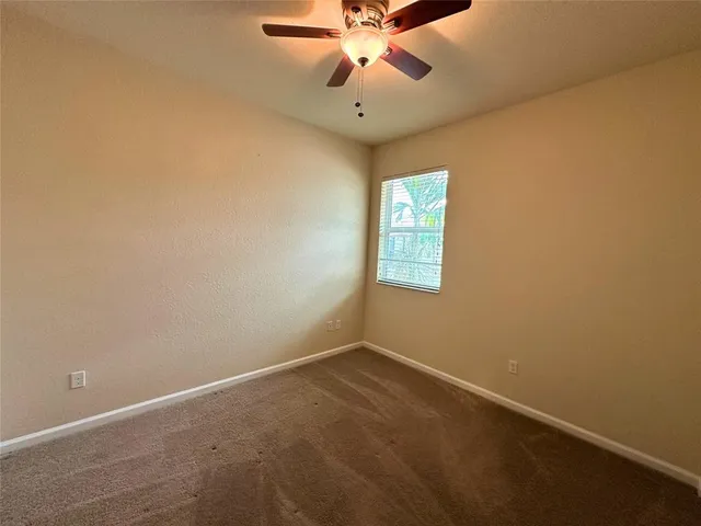an empty room with closet and a chandelier fan