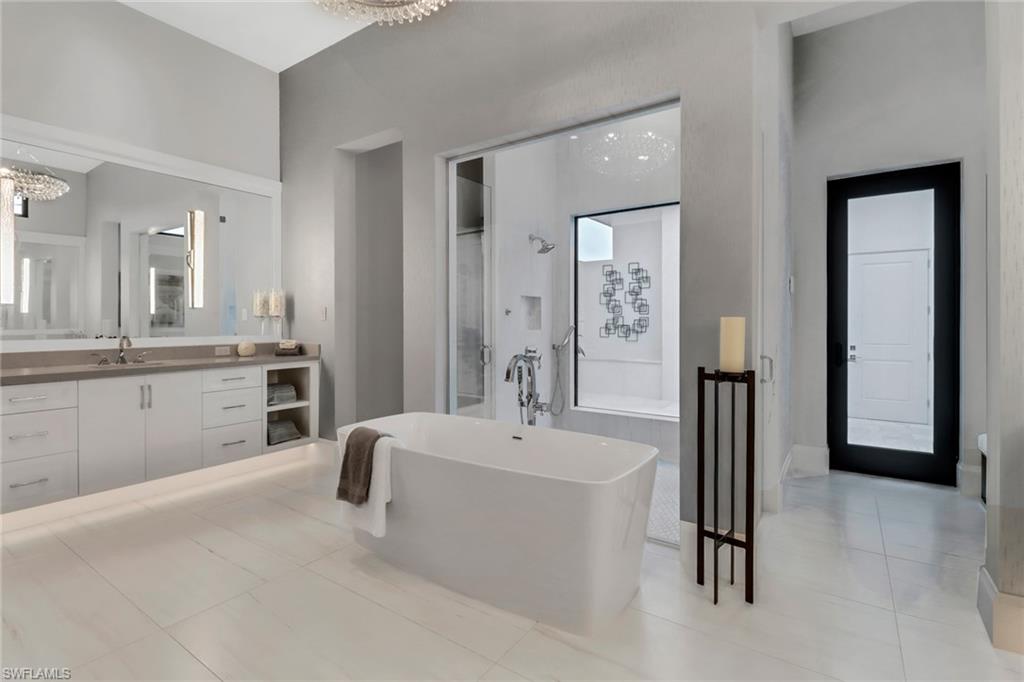 12 Banyan Road Naples, FL 34108 - Photo 16 of 44 a spacious bathroom with a double vanity sink a mirror and a bathtub
