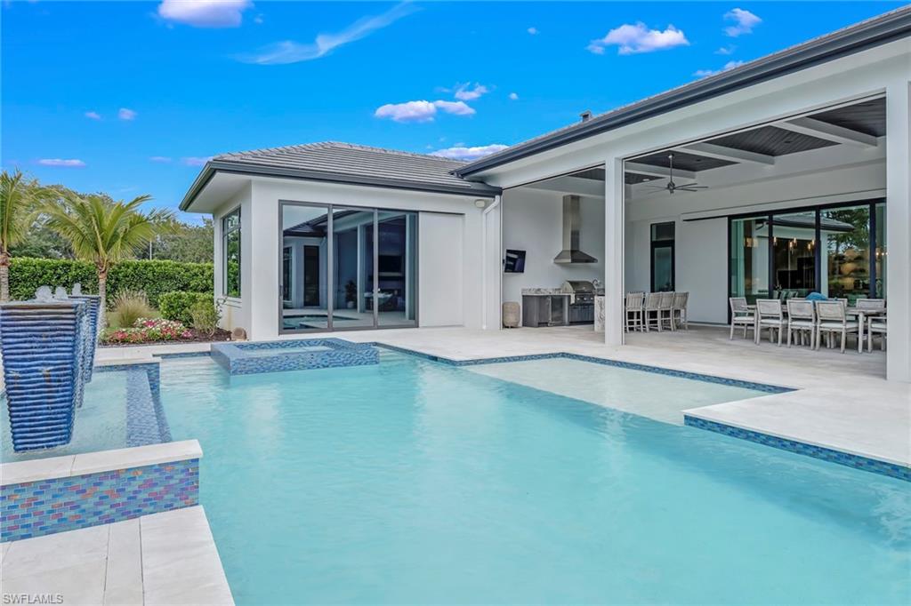 12 Banyan Road Naples, FL 34108 - Photo 38 of 44 a view of a patio with table and chairs with wooden floor and fence