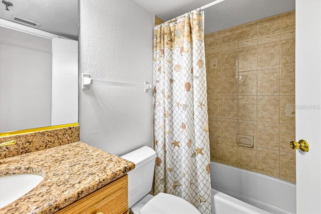 53 West Bay Heights Road, Unit 205 Englewood, FL 34223 - Photo 29 of 43 a bathroom with a granite countertop sink toilet and shower