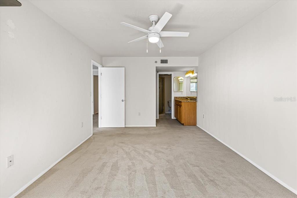 53 West Bay Heights Road, Unit 205 Englewood, FL 34223 - Photo 30 of 43 an empty room with a white walls and ceiling fan