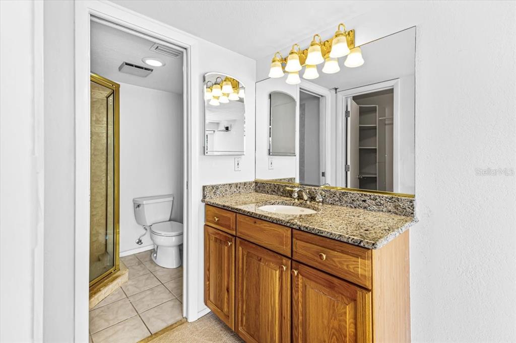 53 West Bay Heights Road, Unit 205 Englewood, FL 34223 - Photo 34 of 43 a bathroom with a granite countertop sink mirror and a toilet