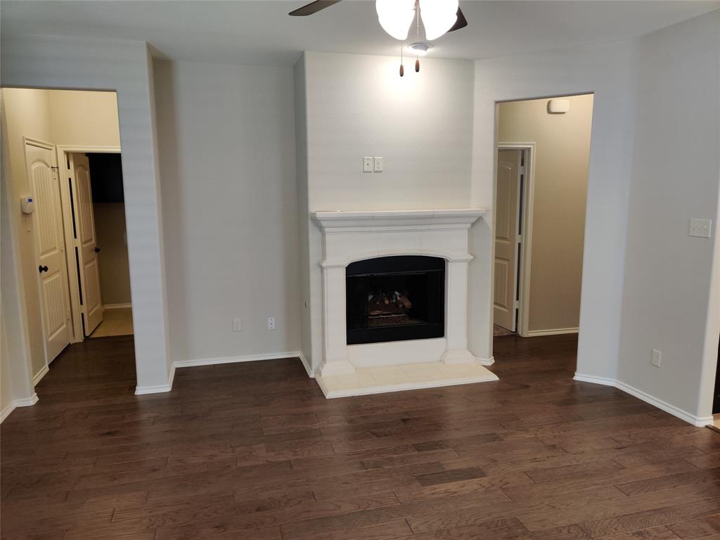 9901 Pronghorn Road McKinney, TX 75071 - Photo 5 of 27 a view of an empty room with wooden floor and a fireplace