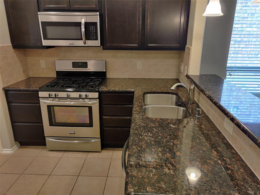 9901 Pronghorn Road McKinney, TX 75071 - Photo 9 of 27 a kitchen with granite countertop a stove top oven microwave and cabinets