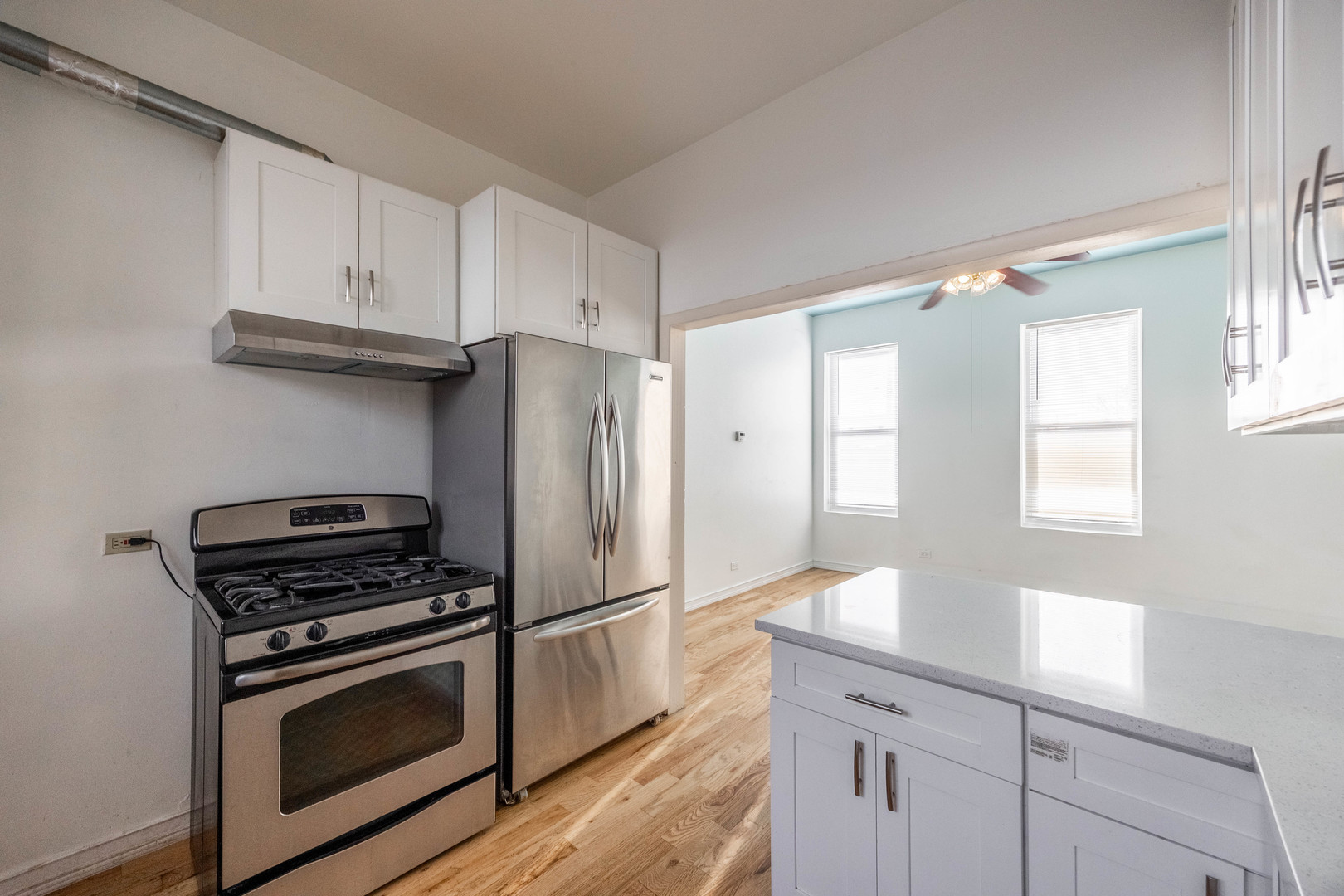 3248 West 25th Street, Unit 2 Chicago, IL 60623 - Photo 4 of 17 a kitchen with granite countertop a refrigerator stove and sink