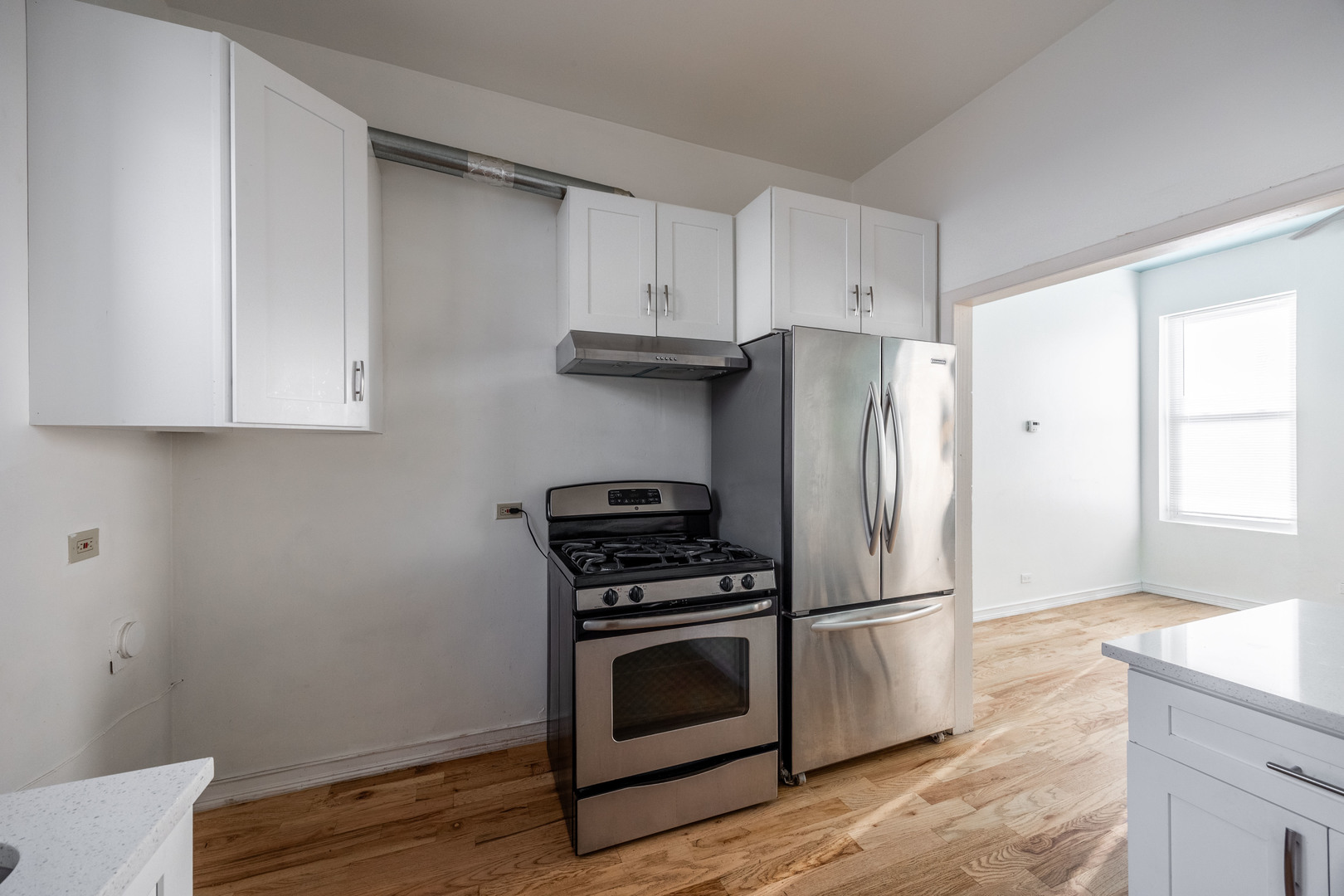 3248 West 25th Street, Unit 2 Chicago, IL 60623 - Photo 5 of 17 a kitchen with granite countertop white cabinets and stainless steel appliances
