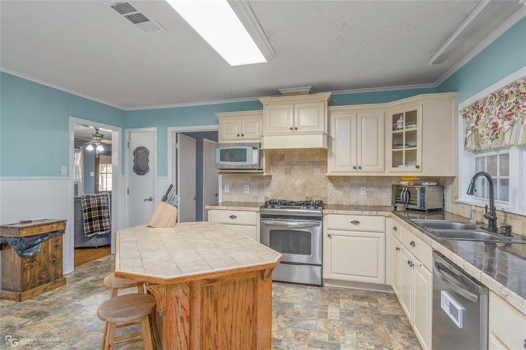 803 Drew Lane Minden, LA 71055 - Photo 11 of 33 a kitchen with stainless steel appliances granite countertop a sink stove refrigerator and white cabinets