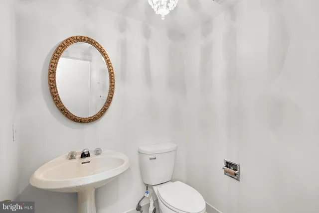a bathroom with a sink a toilet and a mirror