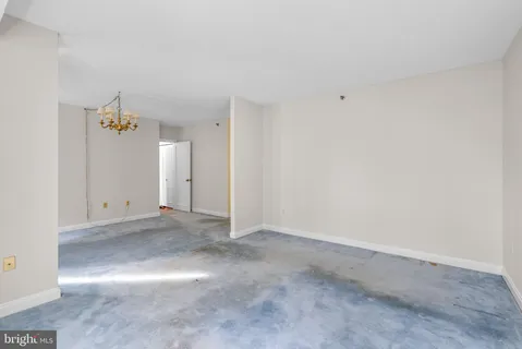 an empty room with closet and windows
