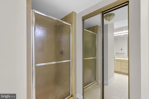 a bathroom with a glass shower door and a mirror