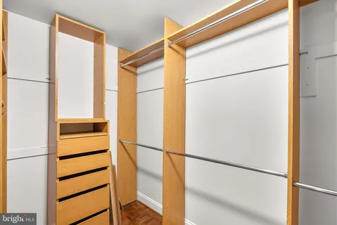 a view of walk in closet with empty racks