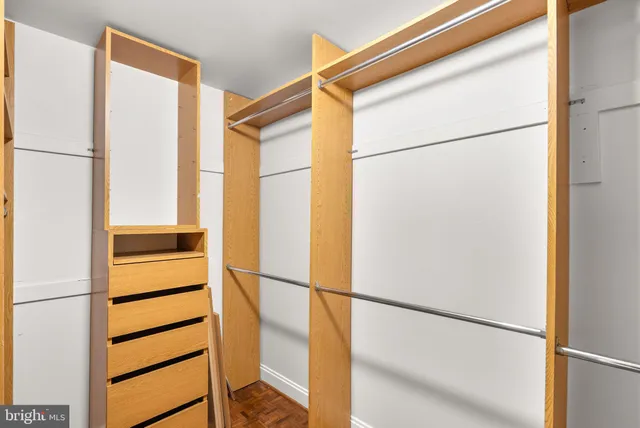 a view of walk in closet with empty racks