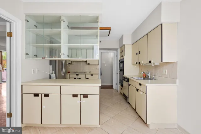 a kitchen with white cabinets and window