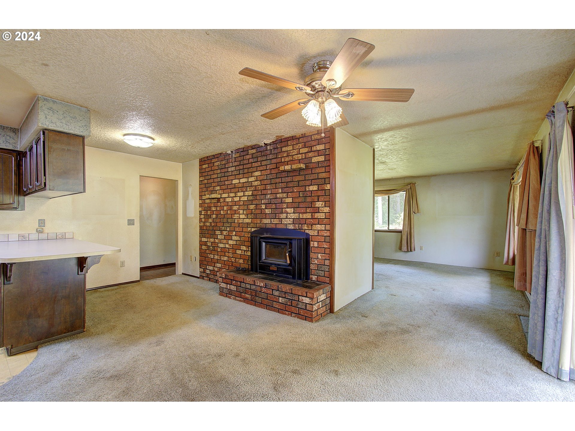 111 Backstrom Road Winlock, WA 98596 - Photo 6 of 30 a view of an empty room with a fireplace and a window