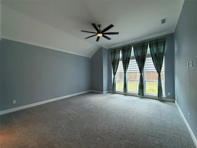an empty room with windows and a ceiling fan