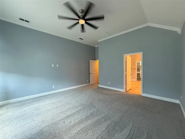 an empty room with a ceiling fan and a window