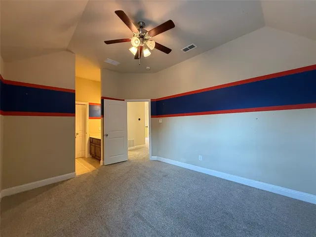 an empty room with a chandelier fan and a large window