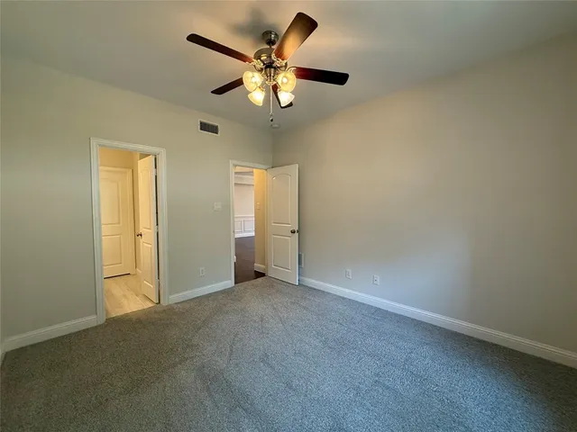 an empty room with chandelier fan