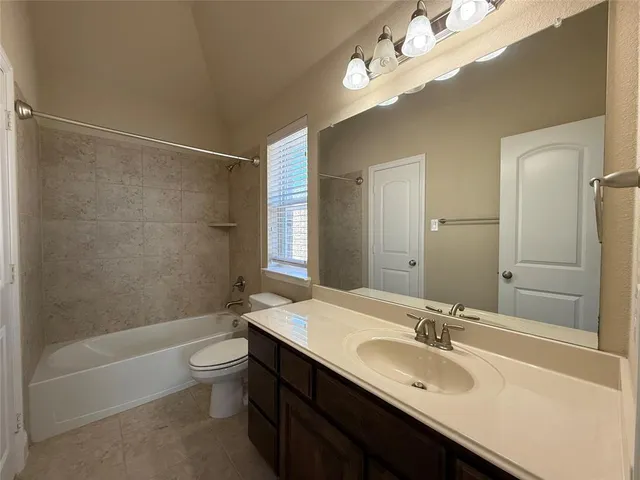 a bathroom with a sink a toilet and a large mirror
