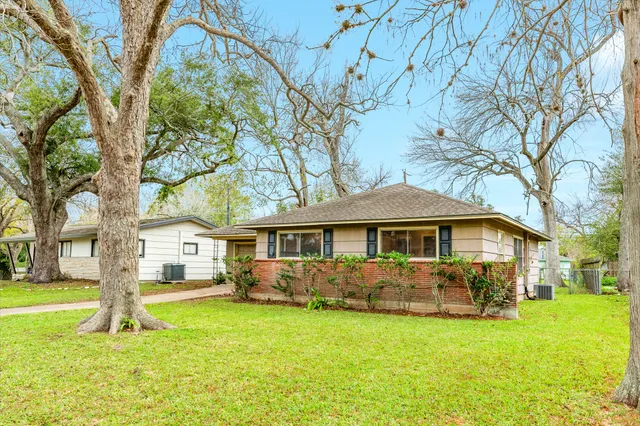 a front view of a house with a yard table and trees