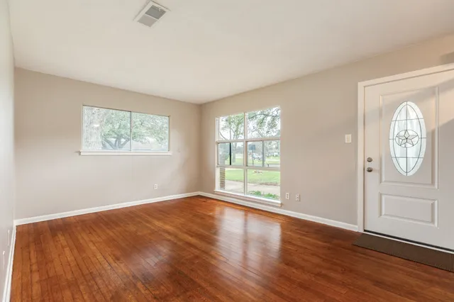 wooden floor in an empty room with a window