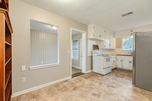 a kitchen with white cabinets and white appliances