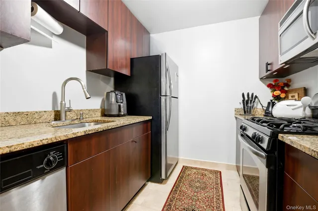 a kitchen with stainless steel appliances granite countertop a stove a sink and a refrigerator
