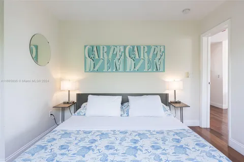 a bedroom with a bed and a lamp on dresser