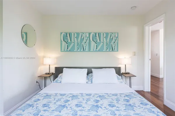 a bedroom with a bed and a lamp on dresser