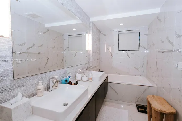 a bathroom with a sink vanity and tub