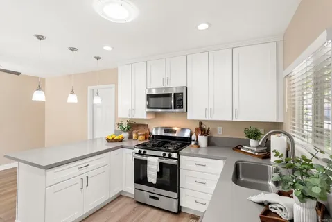 a kitchen with sink a microwave and cabinets