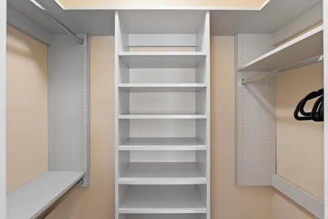a view of walk in closet with empty racks