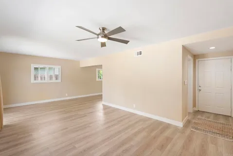 a view of a big room with wooden floor and windows