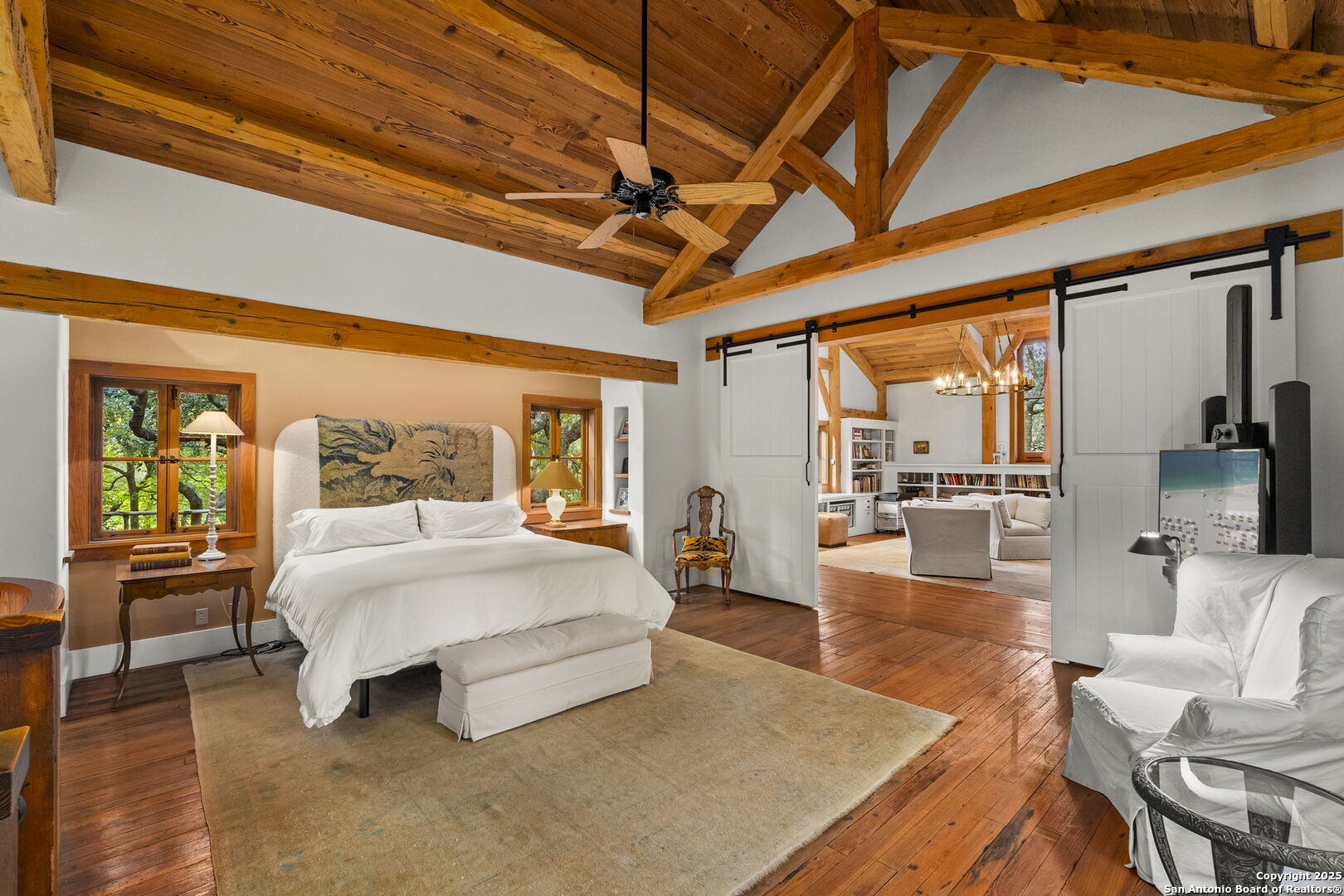 317 Limestone Crk Road Hill Country Village, TX 78232 - Photo 16 of 51 a spacious bedroom with a large bed and a wooden floor