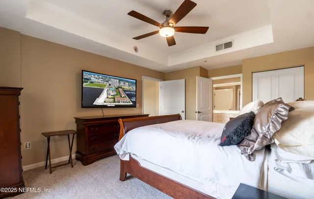 a spacious bedroom with a bed and a chandelier