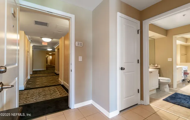 a view of a hallway with bathroom and wooden floor