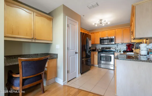 a kitchen with stainless steel appliances granite countertop a refrigerator and a stove top oven