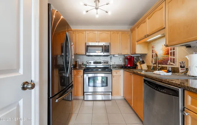 a kitchen with stainless steel appliances granite countertop a stove a sink and a refrigerator