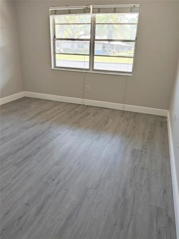 2472 Enterprise Road, Unit 6 Clearwater, FL 33763 - Photo 20 of 22 an empty room with wooden floor and windows