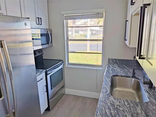 a kitchen with a sink appliances and cabinets