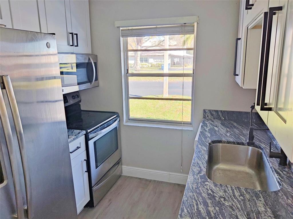 2472 Enterprise Road, Unit 6 Clearwater, FL 33763 - Photo 5 of 22 a kitchen with a sink appliances and cabinets