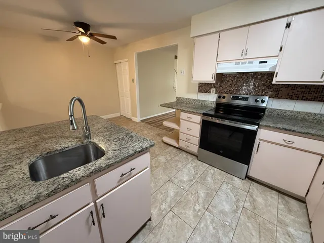 a kitchen with granite countertop a sink stainless steel appliances and cabinets