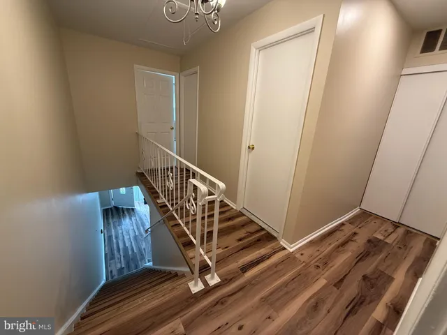 a view of a hallway with wooden floor and entryway
